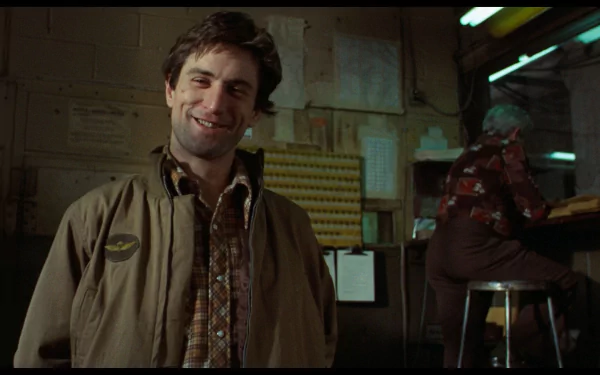 Robert De Niro smiles in a scene from Taxi Driver, captured in this HD desktop wallpaper, showcasing the film's iconic atmosphere and gritty character depiction.