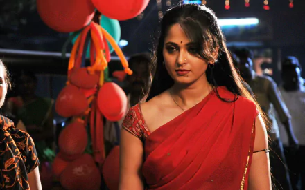 Actress in a red sari amid festive lights and balloons from the film Vaanam — 2K Quad HD PC desktop wallpaper.