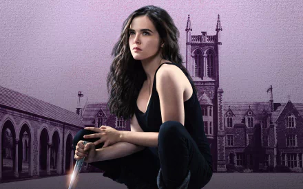 HD PC desktop wallpaper featuring Zoey Deutch from the movie Vampire Academy, seated with a sword in front of a gothic-style academy building.