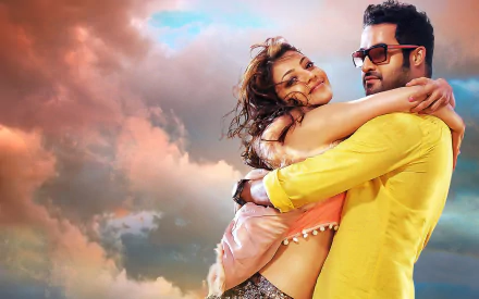 Kajal Aggarwal and N. T. Rama Rao Jr. share a warm embrace in this HD wallpaper from the movie Temper, set against a vibrant sky.