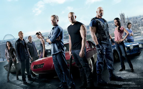 HD wallpaper featuring the cast of the movie Fast & Furious 6, standing in front of cars with a cityscape in the background.