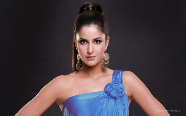 HD desktop wallpaper and background featuring celebrity Katrina Kaif, elegantly dressed in a blue outfit with a floral embellishment, against a dark backdrop.