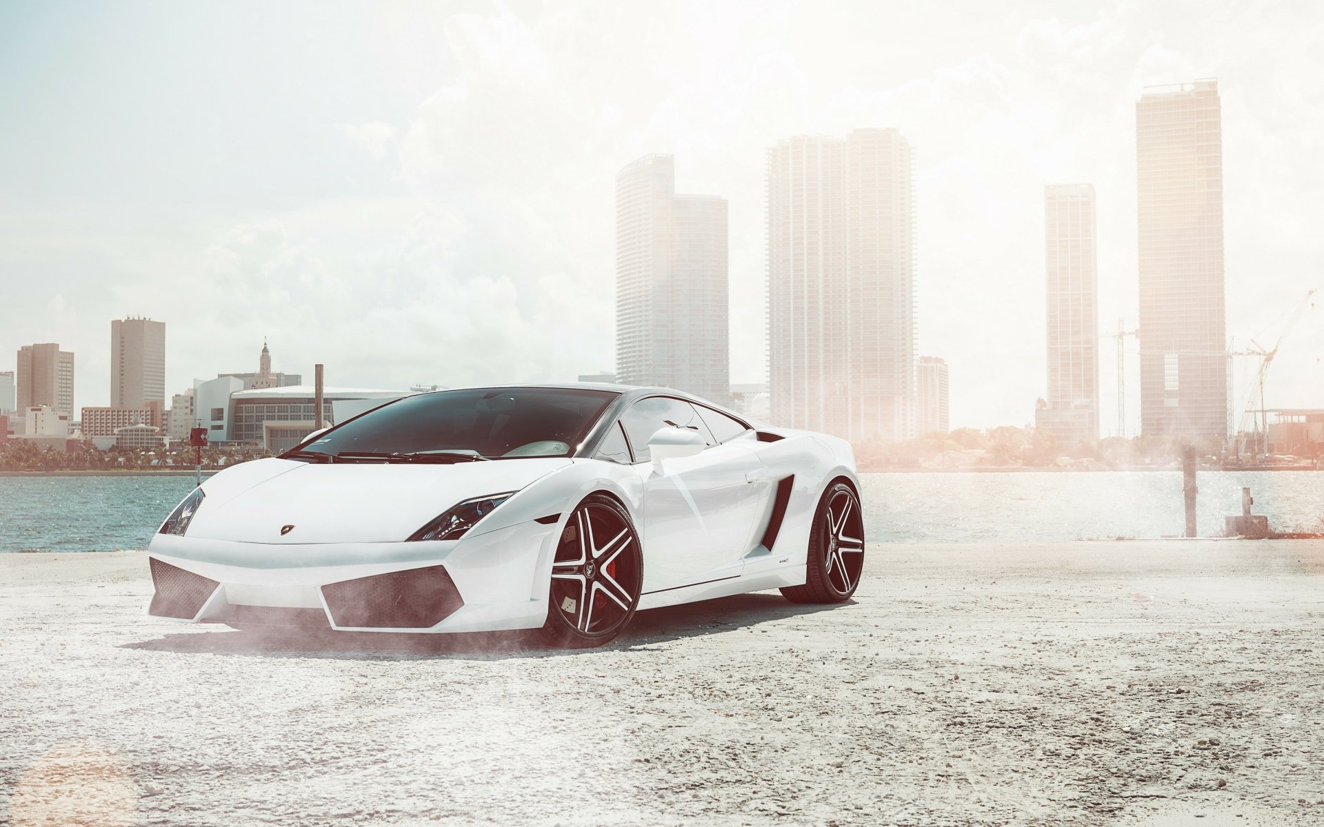 White Lamborghini Gallardo on a waterfront with skyscrapers, high-resolution 4K Ultra HD vehicle desktop wallpaper/background.