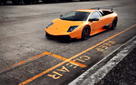 Orange Lamborghini Murcielago LP670-4 SV supercar parked on asphalt with KEEP CLEAR marked in yellow, captured in high-definition for a PC desktop wallpaper.
