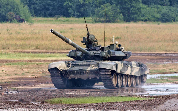 HD desktop wallpaper featuring a T-90 military tank advancing across muddy terrain with forest in the background.