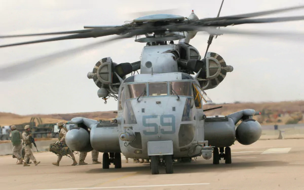 Military Sikorsky CH-53E Super Stallion on a desert tarmac with ground crew, 2K Quad HD PC desktop wallpaper and background.