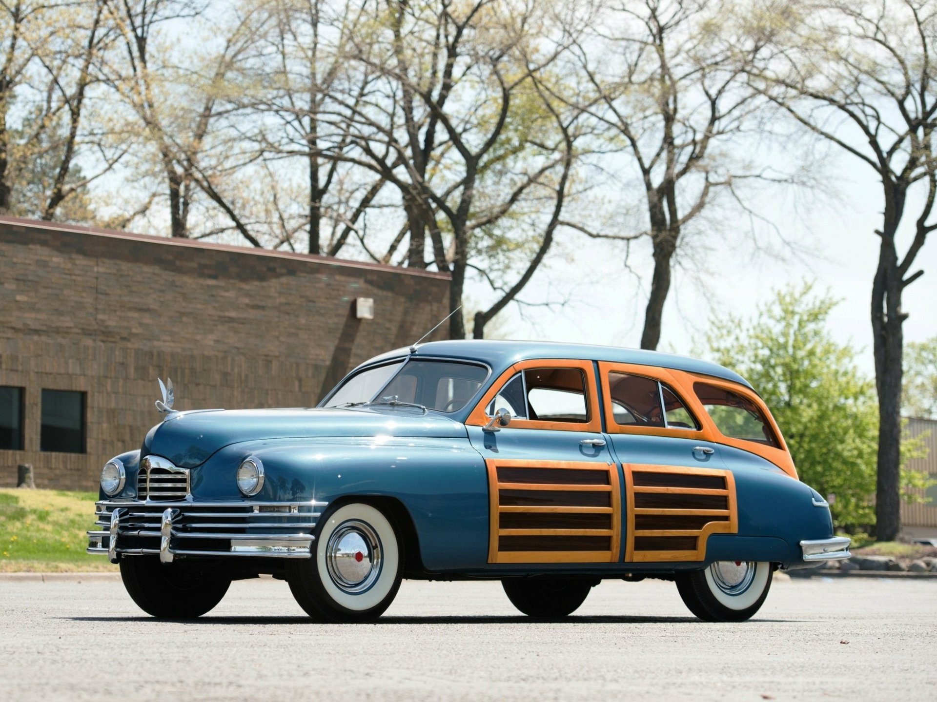 Vintage Packard Station Sedan in blue and wood paneling parked outdoors, captured in high-definition for a PC desktop wallpaper and background.