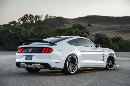 A sleek white Ford Mustang parked against a scenic backdrop, showcasing its dynamic design and sporty features. This HD image serves as an impressive desktop wallpaper.