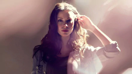 HD PC desktop wallpaper featuring singer Lena Meyer-Landrut bathed in soft, warm light with a focused expression, highlighting her music persona.