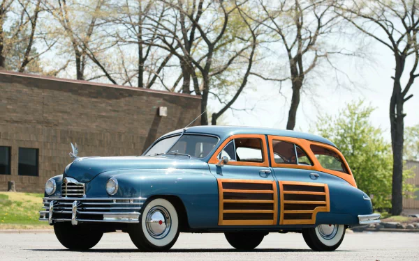 Vintage Packard Station Sedan in blue and wood paneling parked outdoors, captured in high-definition for a PC desktop wallpaper and background.