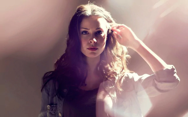 HD PC desktop wallpaper featuring singer Lena Meyer-Landrut bathed in soft, warm light with a focused expression, highlighting her music persona.