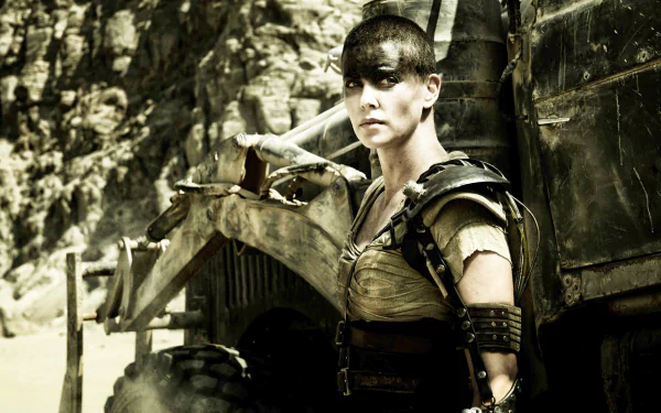 Imperator Furiosa, played by Charlize Theron in Mad Max: Fury Road, stands resolute beside a rugged vehicle in a 4K Ultra HD movie wallpaper.
