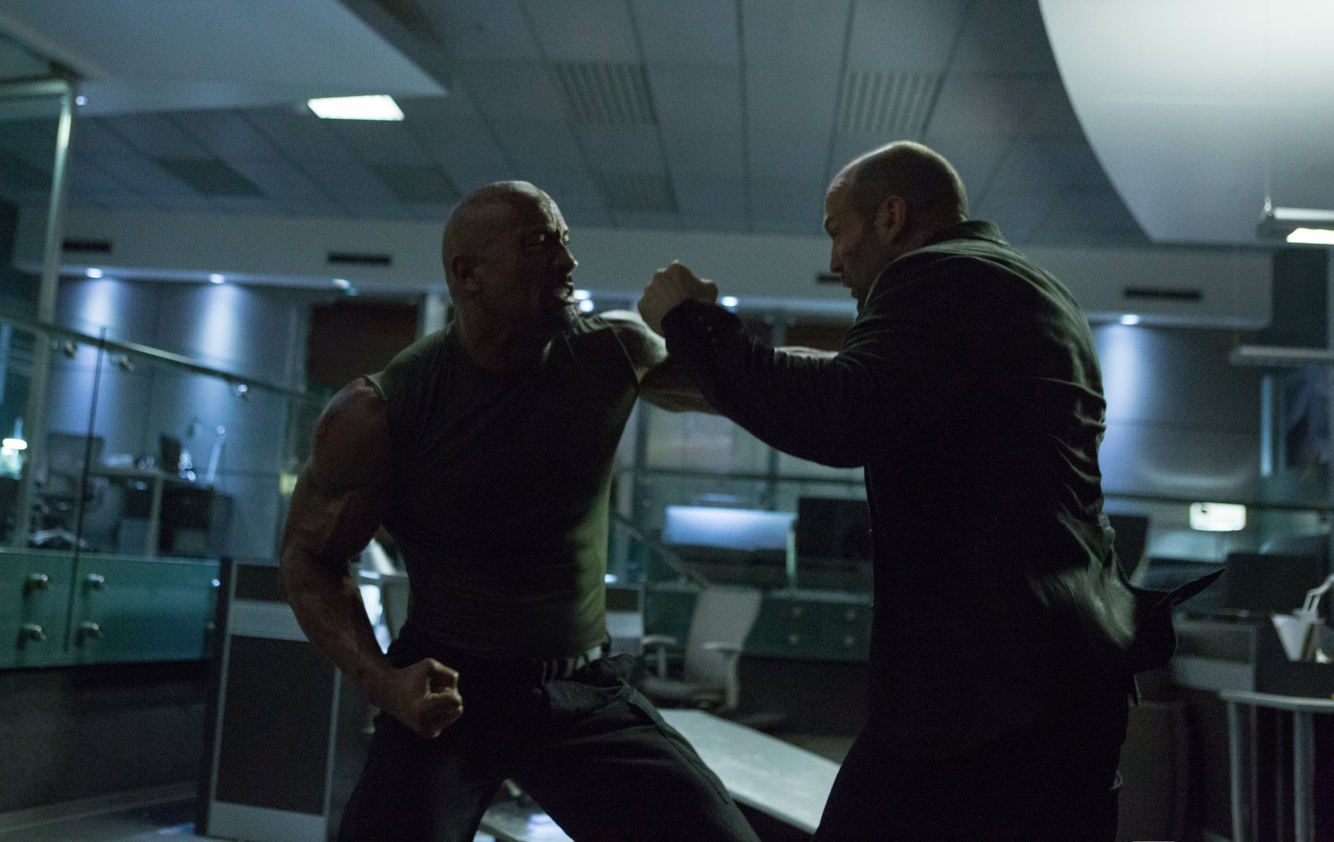 Dwayne Johnson as Luke Hobbs and Jason Statham as Deckard Shaw engage in an intense fight scene from Furious 7, set in a high-tech environment. High-definition movie wallpaper.