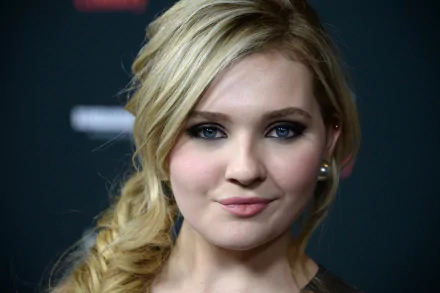 Close-up of Abigail Breslin, a celebrity known for her roles in film and television, with a stylish braid and striking blue eyes. An HD wallpaper capturing her captivating look.