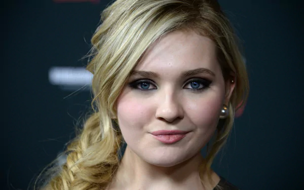 Close-up of Abigail Breslin, a celebrity known for her roles in film and television, with a stylish braid and striking blue eyes. An HD wallpaper capturing her captivating look.