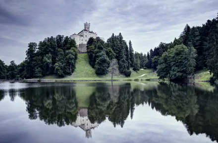 Trakošćan Castle with its tower reflects on the calm lake, surrounded by lush greenery in Croatia, captured in stunning 4K Ultra HD.