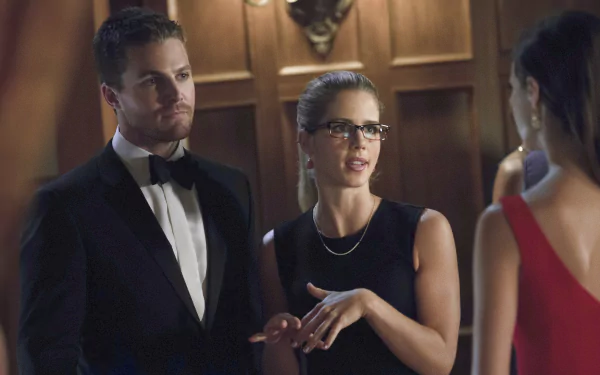 HD desktop wallpaper featuring Stephen Amell as Oliver Queen and Emily Bett Rickards as Felicity Smoak from the TV show Arrow in an elegant indoor setting.