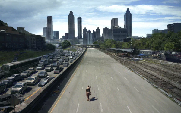 Rick Grimes rides through a deserted highway, city skyline in the distance, capturing the post-apocalyptic vibe of The Walking Dead in this HD desktop wallpaper.