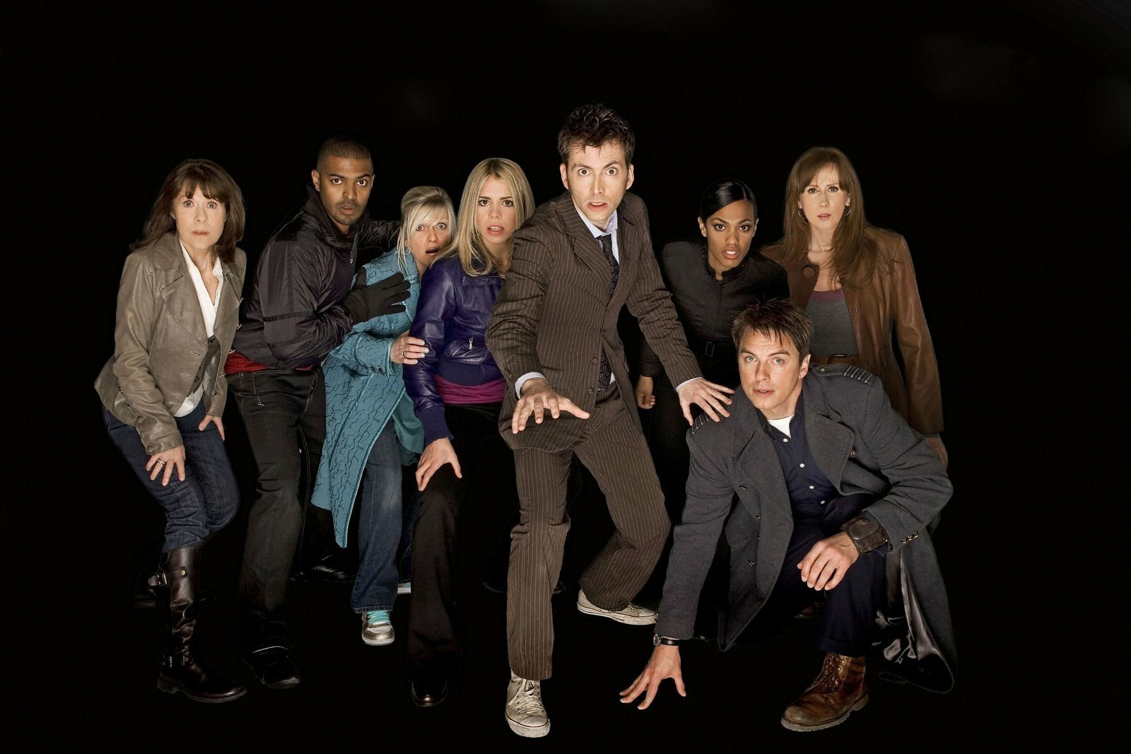 HD PC desktop wallpaper featuring the main cast of the TV show Doctor Who (2005) posed dynamically against a black background.