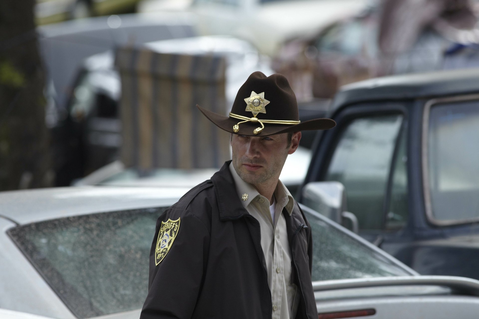 Rick Grimes, portrayed by Andrew Lincoln, stands in a desolate setting, reflecting the intense atmosphere of The Walking Dead in this stunning 4K Ultra HD wallpaper.