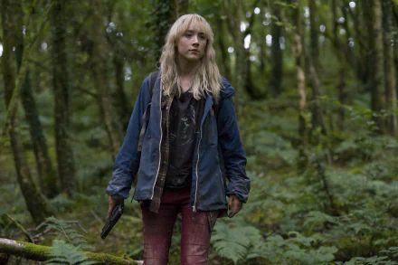 4K Ultra HD PC wallpaper: a young blonde woman in a blue jacket and bloodstained jeans holding a gun, standing in a dense green forest — cinematic movie still.