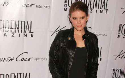 HD desktop wallpaper of a female celebrity in a black leather jacket posing against a magazine event backdrop.