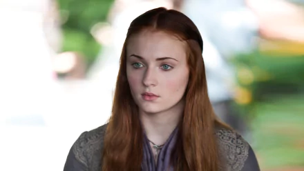 HD wallpaper featuring Sansa Stark, portrayed by Sophie Turner, from the TV show Game of Thrones, capturing her thoughtful expression in a captivating background.