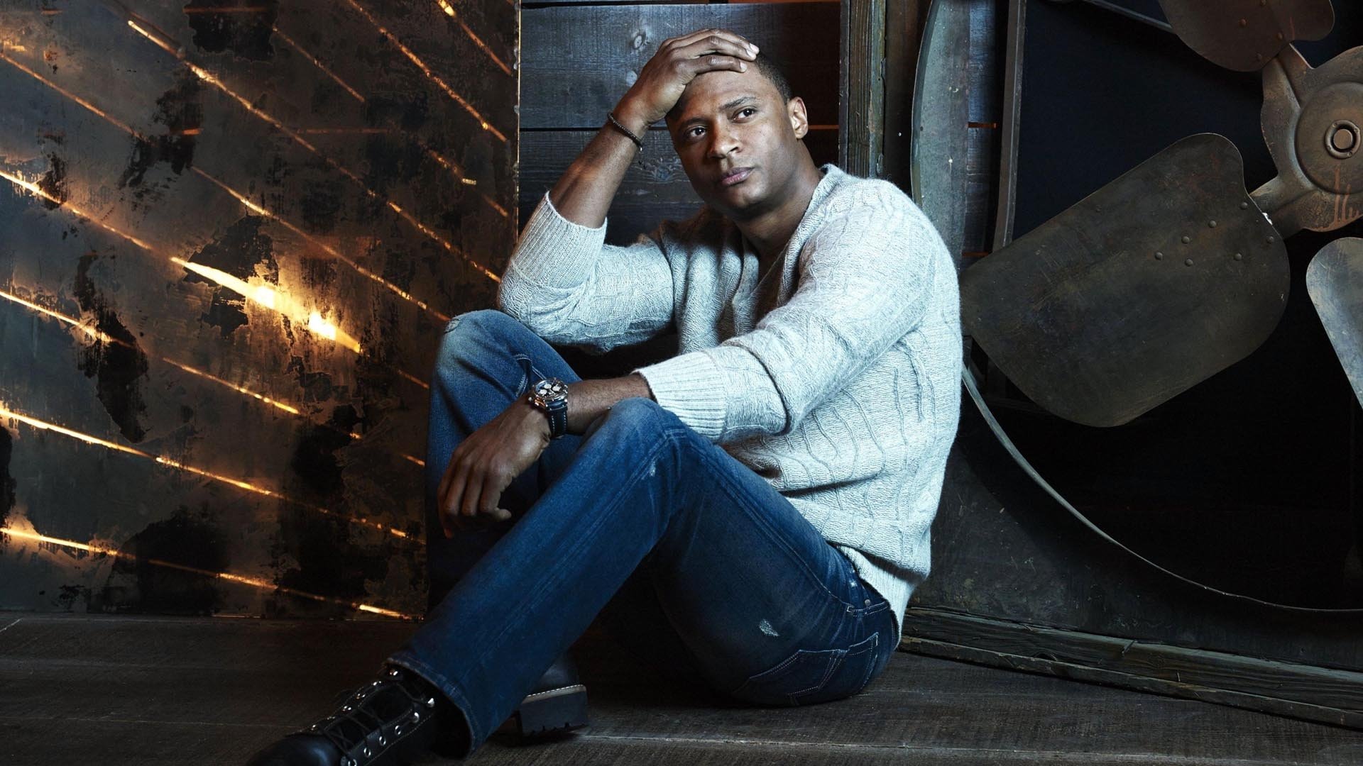 David Ramsey from Arrow TV Show sits casually against an industrial backdrop in this HD desktop wallpaper and background.