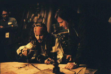 Jack Sparrow, played by Johnny Depp, studies a map in a scene from the movie Pirates of the Caribbean: Dead Man's Chest, captured as an HD PC desktop wallpaper.