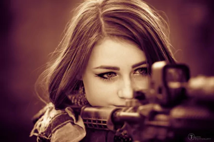 HD desktop wallpaper of a focused woman, tagged Girls & Guns, gazing intently through the scope of a gun with a warm sepia tone background.