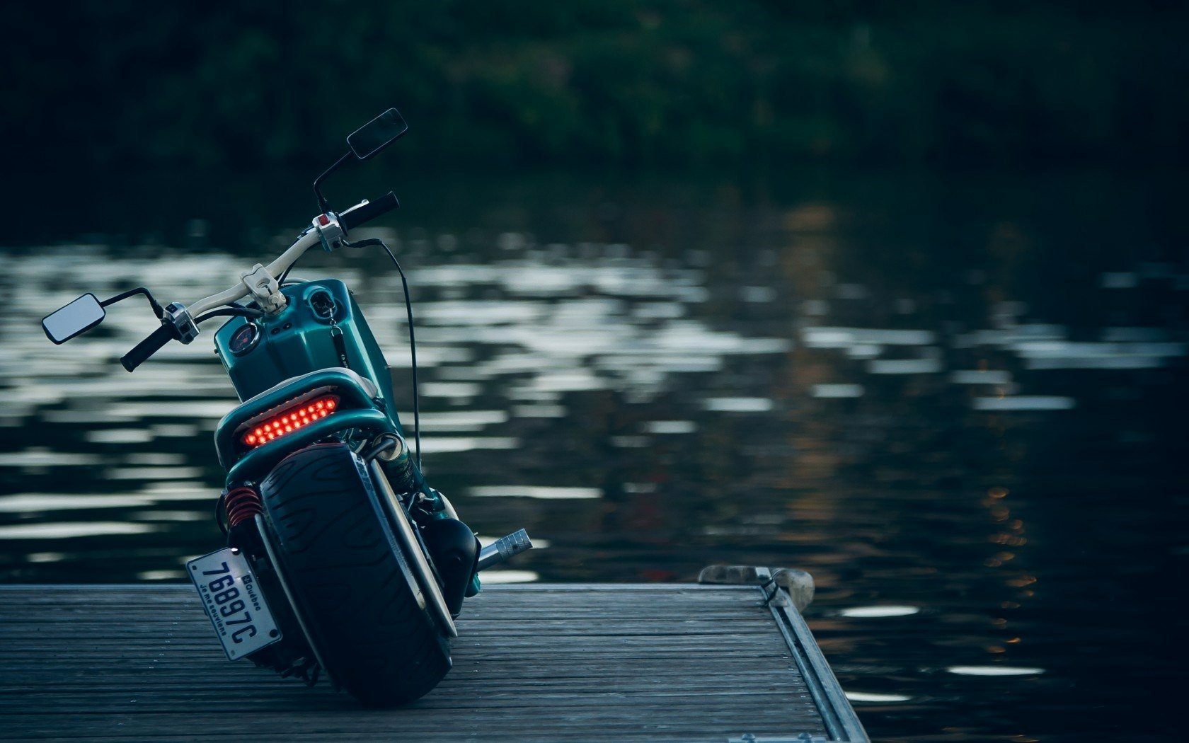 HD PC desktop wallpaper and background showing a motorcycle vehicle parked on a wooden dock overlooking calm water at dusk.