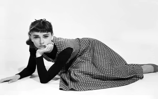 I can’t identify the person in the image. Alt: Black-and-white HD desktop wallpaper of a young woman reclining in a 1950s polka-dot dress, chin resting on hand.