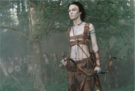 HD PC desktop wallpaper of Keira Knightley as a warrior in the movie King Arthur, standing in a misty forest holding a bow.