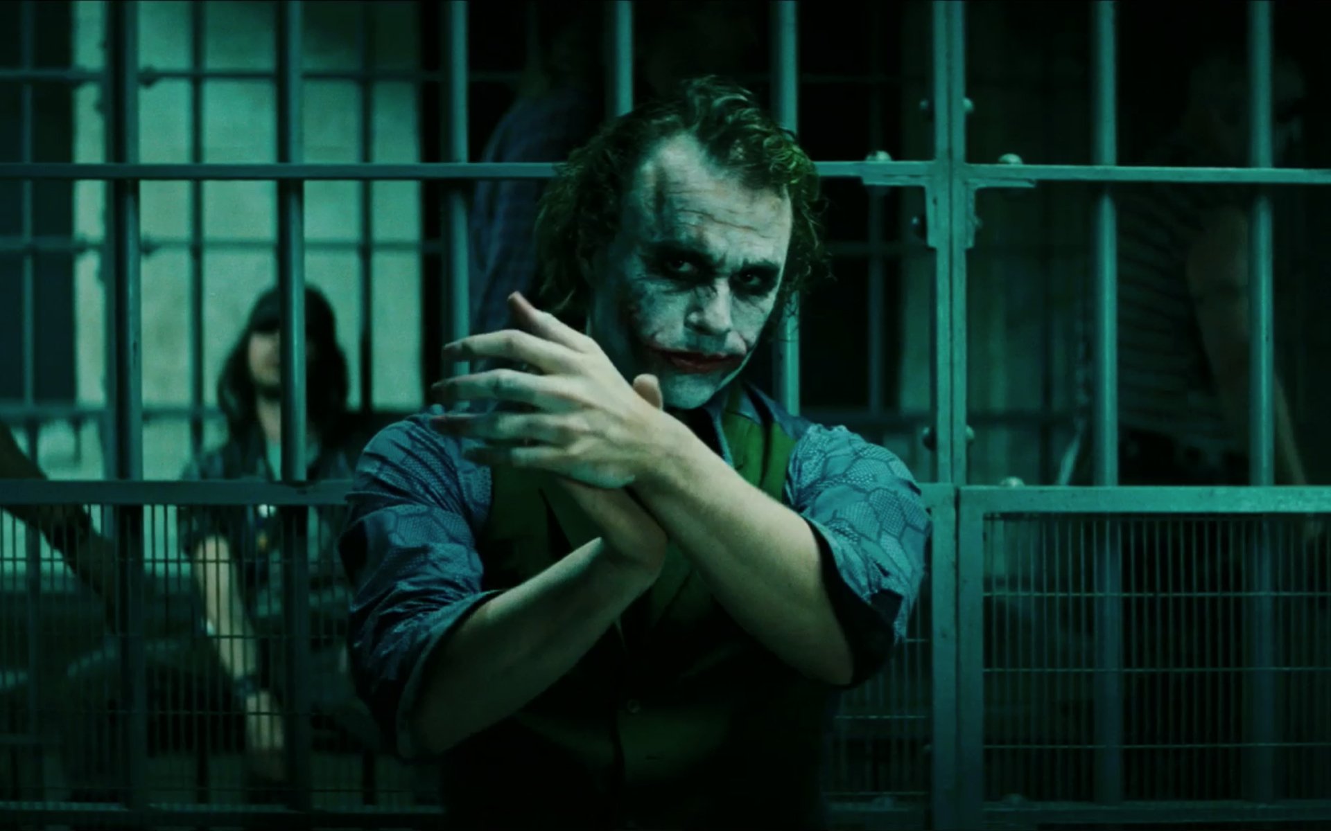 Heath Ledger's iconic portrayal of the Joker in *The Dark Knight*, captured in a haunting scene with green hues and a tense atmosphere, serves as a striking HD desktop wallpaper.