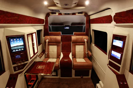 HD PC desktop wallpaper showing the luxurious interior of a Mercedes-Benz Sprinter vehicle with leather seating and built-in digital screens.