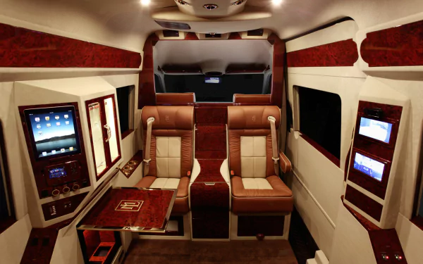 HD PC desktop wallpaper showing the luxurious interior of a Mercedes-Benz Sprinter vehicle with leather seating and built-in digital screens.