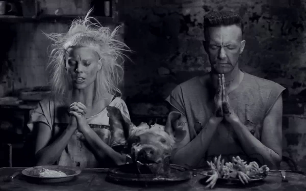 Black and white HD desktop wallpaper featuring members of Die Antwoord in a haunting, artistic scene with a pig's head and religious prayer poses.