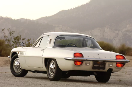 Rear three-quarter view of a white Mazda Cosmo coupe parked on a desert road with mountains — 4K Ultra HD PC desktop wallpaper/background.