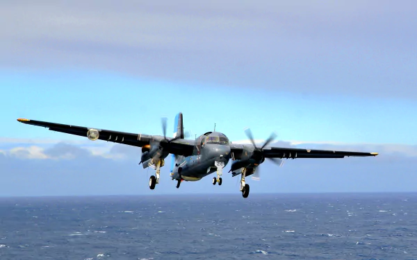 Grumman S-2 Tracker military aircraft flying low over the ocean, rendered as a 2K Quad HD PC desktop wallpaper and background.