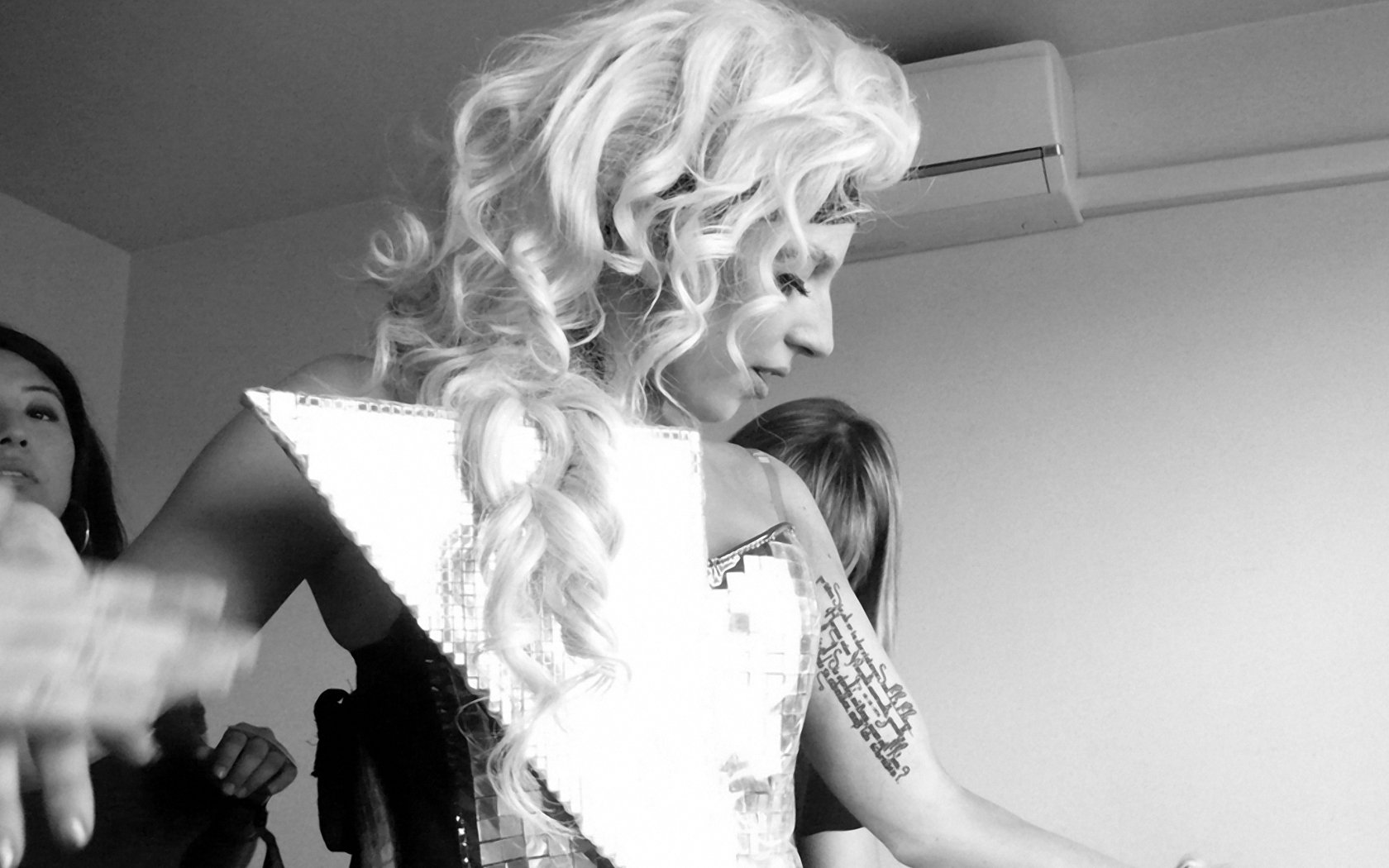 Black and white HD desktop wallpaper featuring Lady Gaga in a dramatic outfit, captured backstage in a candid music moment.
