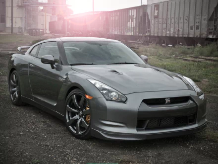 A sleek gray Nissan GT-R showcases its powerful design against an industrial background, serving as an impressive HD wallpaper for any desktop.
