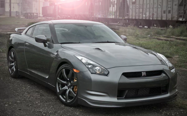 A sleek gray Nissan GT-R showcases its powerful design against an industrial background, serving as an impressive HD wallpaper for any desktop.