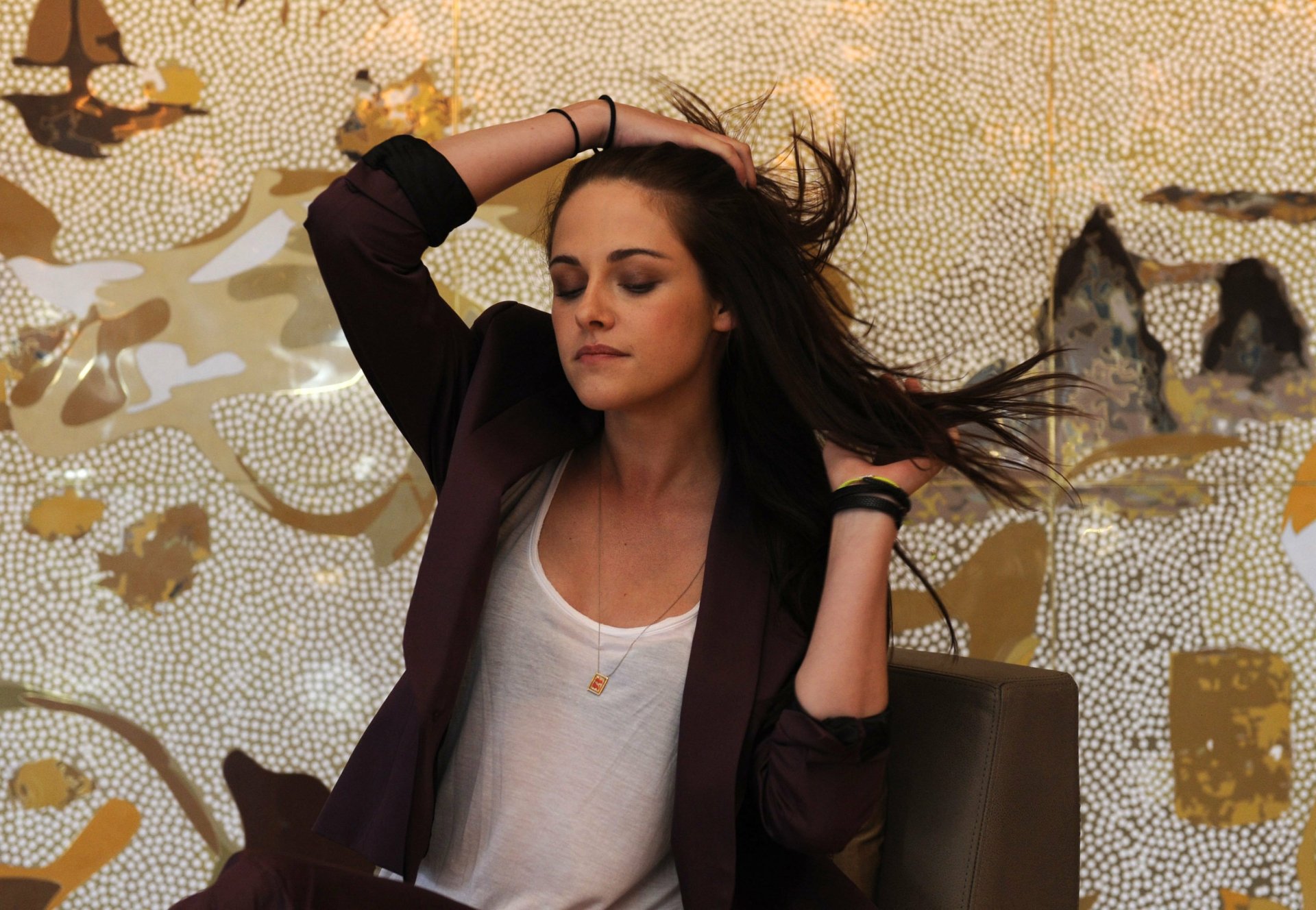 A striking HD desktop wallpaper featuring actress Kristen Stewart, captured in a moment of contemplation with her hair flowing, set against an artistic background.