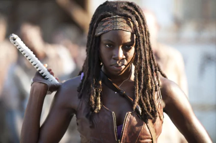 Michonne from The Walking Dead, portrayed by Danai Gurira, fiercely grips her katana, ready to face the undead in this striking HD wallpaper from the iconic TV show.