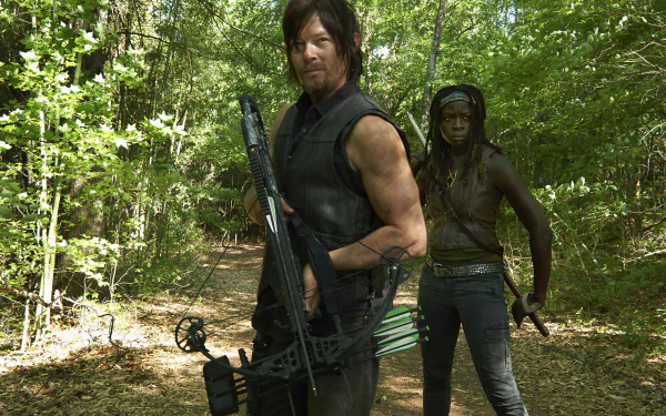HD desktop wallpaper from The Walking Dead featuring Daryl Dixon (Norman Reedus) with a crossbow, and Michonne (Danai Gurira) standing in a wooded area.