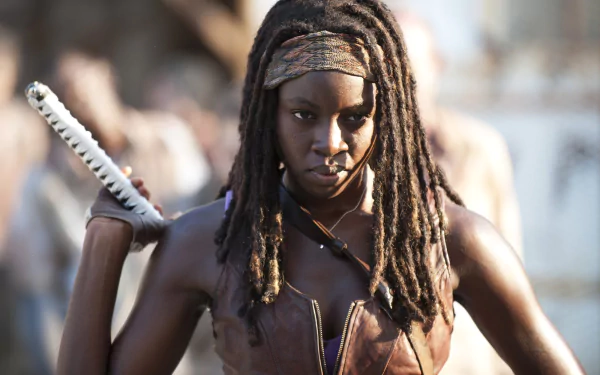 Michonne from The Walking Dead, portrayed by Danai Gurira, fiercely grips her katana, ready to face the undead in this striking HD wallpaper from the iconic TV show.