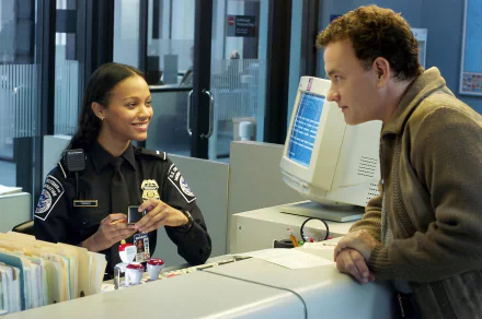 HD desktop wallpaper featuring Zoe Saldana and Tom Hanks in a scene from the movie The Terminal, with Saldana in uniform and Hanks leaning on a counter.