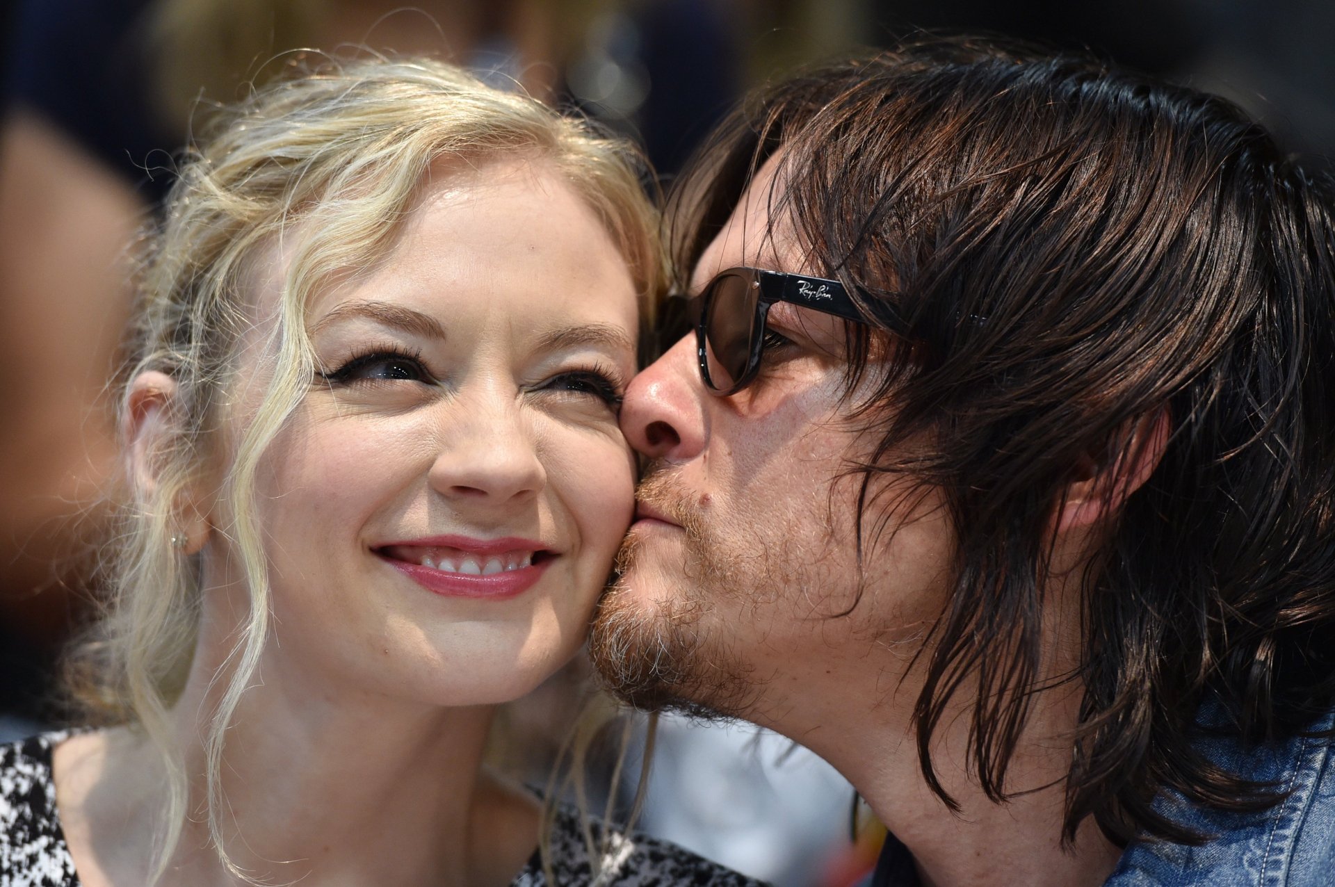 HD PC wallpaper featuring actors Norman Reedus and Emily Kinney, captured in a candid, affectionate moment.