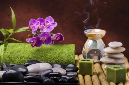 4K Ultra HD still life of a spa scene with vibrant purple orchid, green towel, candle, aromatic oil burner, salt, stacked stones, and smooth black stones on bamboo mat.