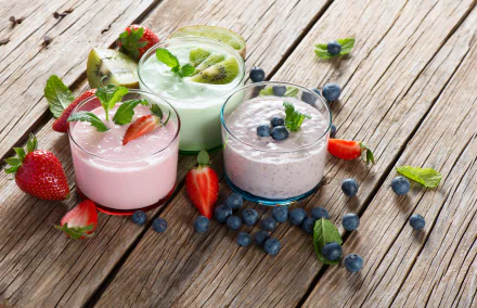 A vibrant assortment of smoothies featuring blueberries, strawberries, and kiwi, set on a rustic wooden table, capturing fresh fruit and a healthy aesthetic in stunning 4K Ultra HD.